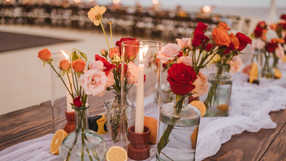 Wedding table decorations with flowers and candles creating a romantic and elegant atmosphere. A mix of tall and short candles.