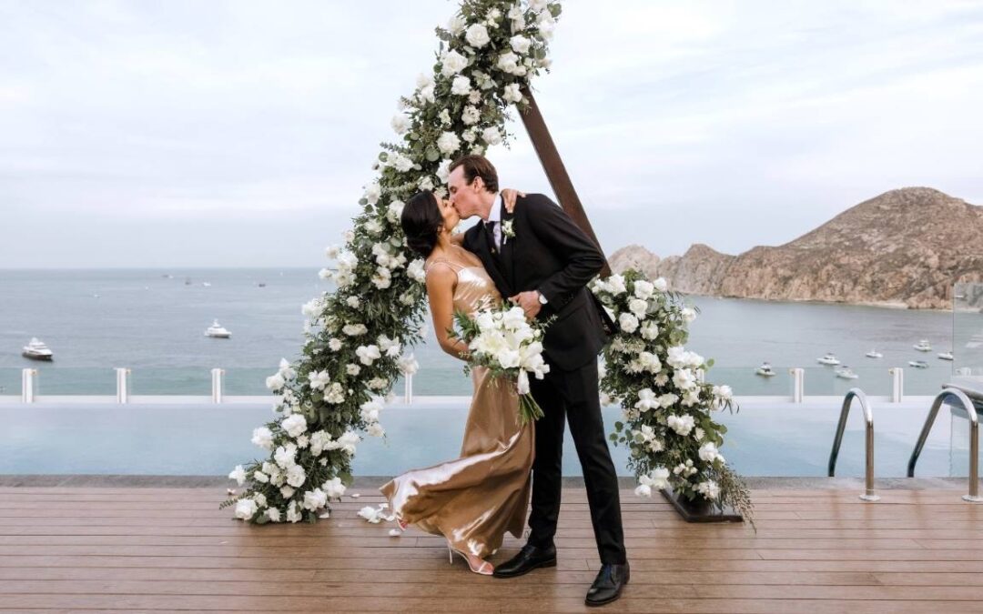 A couple is shown kissing after their wedding ceremony in Los Cabos.