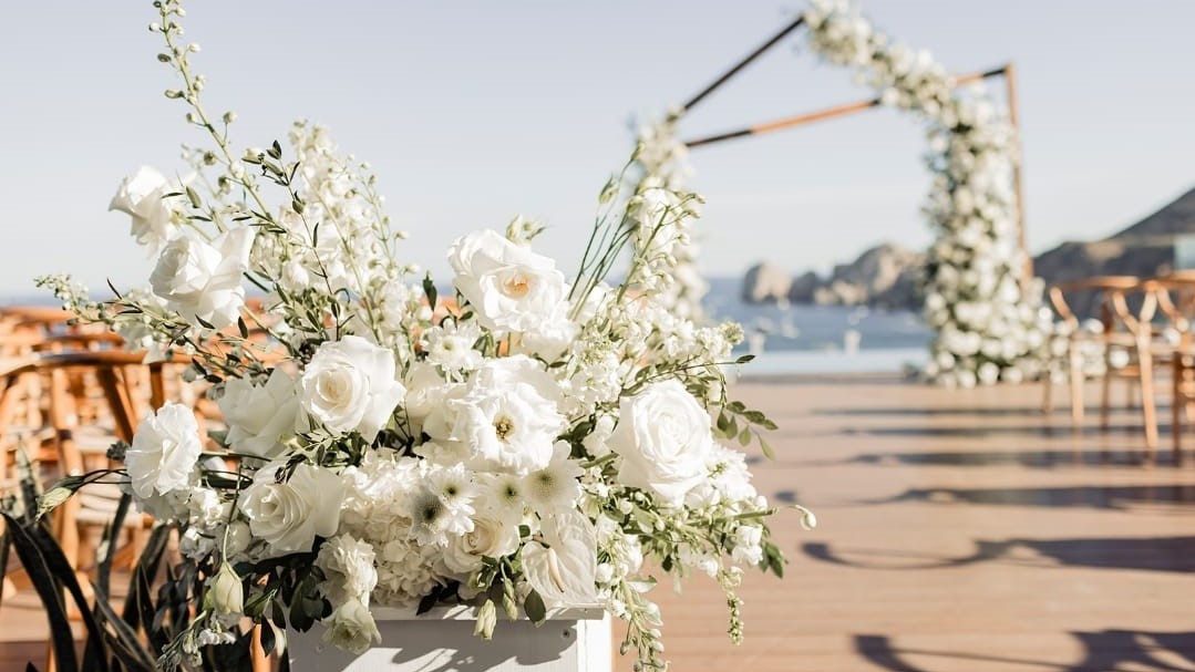 Floral arch and aisle decor set up for an outdoor destination wedding in Cabo Mexico